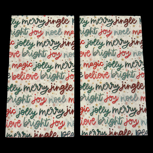 Two Guest size decoupage napkin featuring colorful Christmas word art with phrases like joy, merry, bright, jingle, and believe in red, green, and gold.