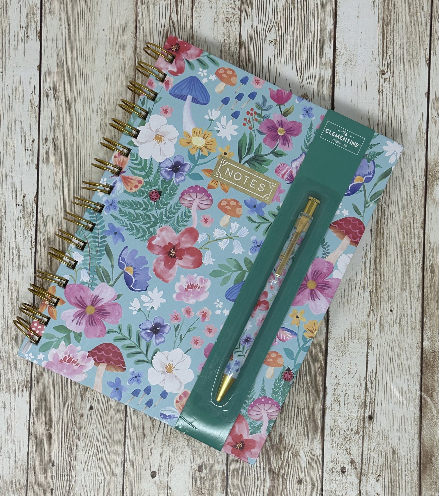 Libreta con flores azules y bolígrafo en papel Clementine