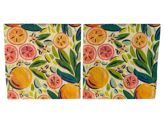 Close-up of two bright luncheon napkins featuring watercolor oranges, grapefruit, and green leaves designed by Kristen Vogel on a light cream background.