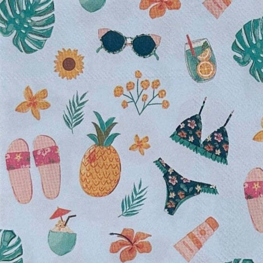 Napkin with tropical pattern including pineapple, bikini, and sunglasses on a light blue background