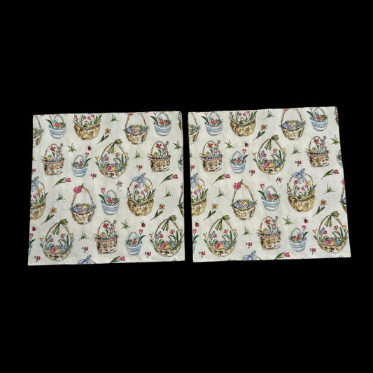 Two Cocktail size decoupage napkin featuring Easter baskets filled with flowers, eggs, and ribbons on a white background for spring and Easter crafts.