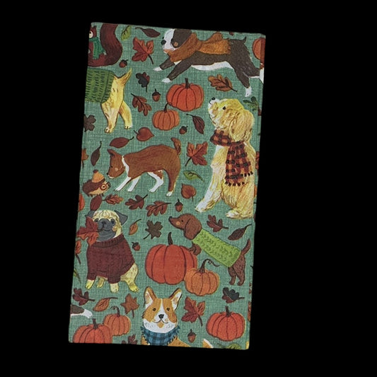a guest towel with a green background with dogs in sweaters and scarves, pumpkins and leaves. Use for paper crafts