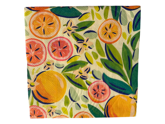 Close-up of a bright luncheon napkin featuring watercolor oranges, grapefruit, and green leaves designed by Kristen Vogel on a light cream background.